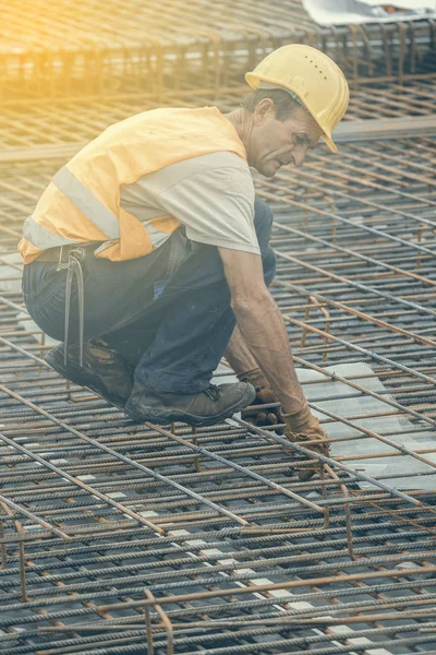 Järnarbetaren poserar på byggarbetsplats — Stockfoto