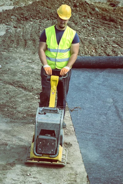 Worker with vibrating plate compactor 4 — Stock Photo, Image