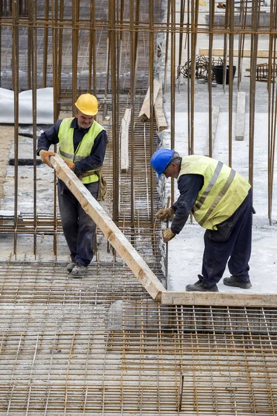 Trabalhadores com pé de cabra remove cofragens de madeira — Fotografia de Stock