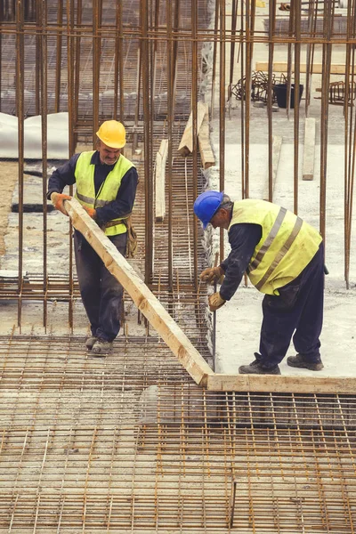 Trabalhadores com pé de cabra remove cofragens de madeira 5 — Fotografia de Stock