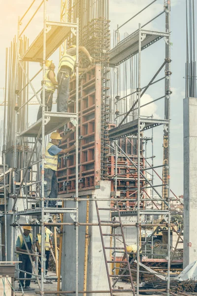 Travailleurs de la construction installant le moule à piliers en béton 2 — Photo