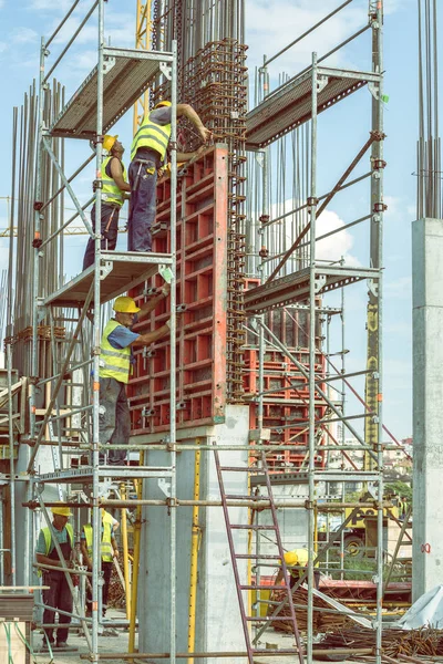 Travailleurs de la construction installant le moule à piliers en béton 4 — Photo