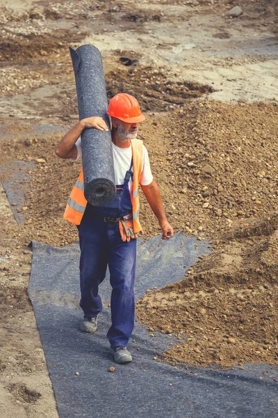 Werknemer uitvoering rolt van geotextiel isolatie 5 — Stockfoto