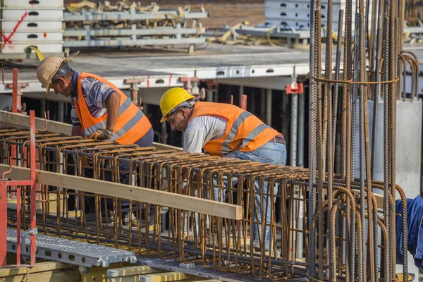 Workers ties reinforcement bar — Stock Photo, Image