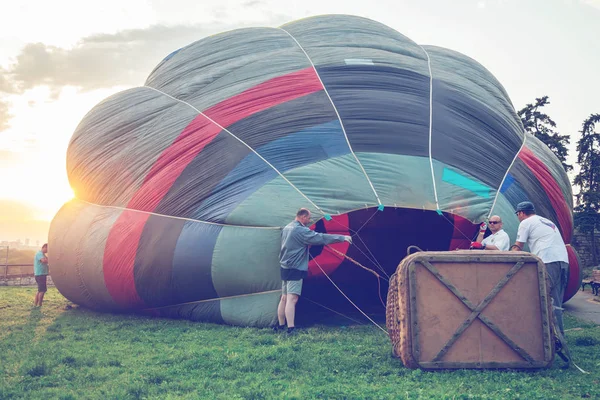 Załogi o zachodzie słońca przygotować balon na gorące powietrze — Zdjęcie stockowe