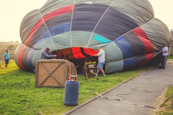 Bemanning, assemblage en vullen van de hete luchtballon — Stockfoto