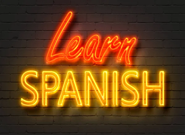 Lär dig spanska, neonskylt på tegelvägg — Stockfoto