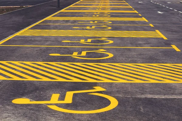 Parkeringsplass med malt gult tegn på rullestol 2 – stockfoto