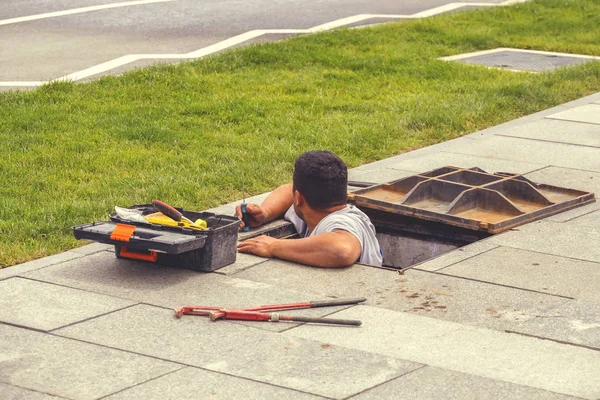 Travaillant dans un trou d'homme, travailleur effectuant des réparations sur l'approvisionnement en eau 2 — Photo