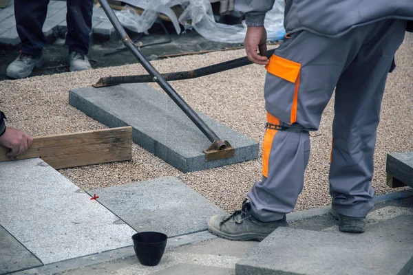 Trabalhadores construtores colocar grandes lajes de pavimentação — Fotografia de Stock