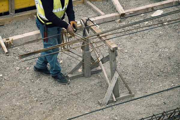 Mãos do trabalhador fazendo estrutura de metal de reforço — Fotografia de Stock