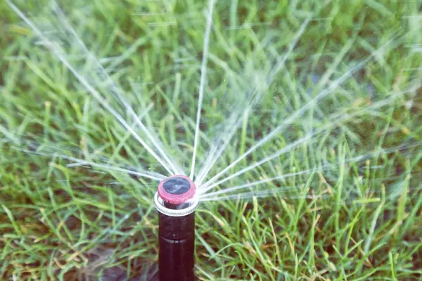 Aspersor automático cabeza dispersando agua en la hierba 3 —  Fotos de Stock