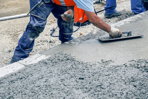 Bauarbeiter nivellieren Beton von Hand mit Kelle 2 — Stockfoto