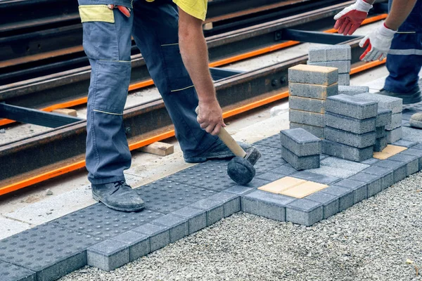 Werknemer hand met hamer plaatst beton bestrating steen 2 — Stockfoto