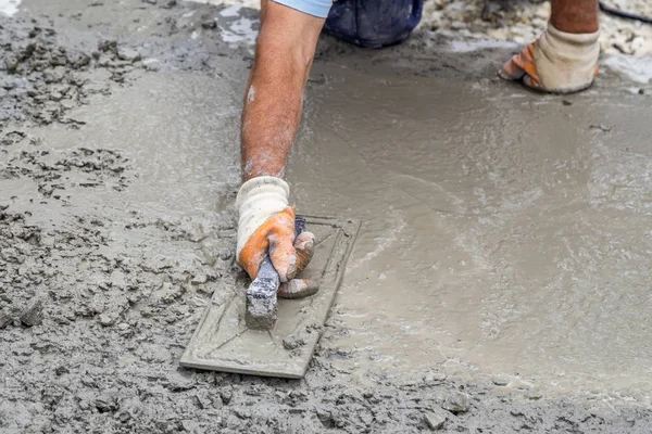 Werknemer hand met Troffel herverdeling van beton — Stockfoto