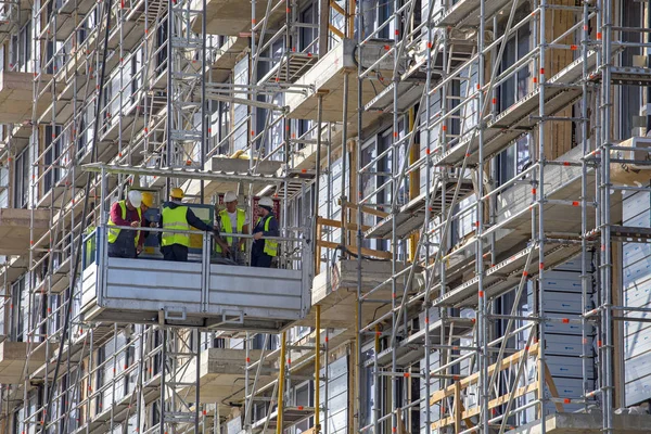 Ascensor industrial para edificio alto con trabajadores de la construcción — Foto de Stock