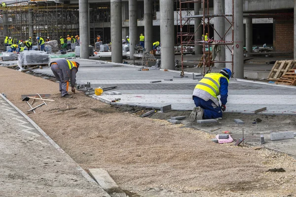 Trabalhadores da construção civil que colocam pedras de pavimentação — Fotografia de Stock