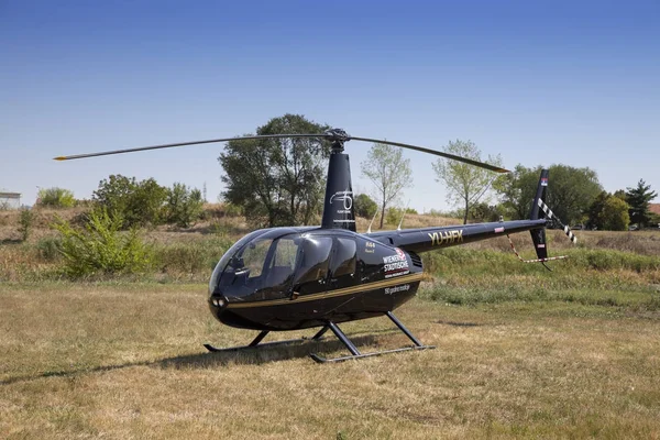 Schwarzer Robinsonhubschrauber r44 geparkt im Gras — Stockfoto