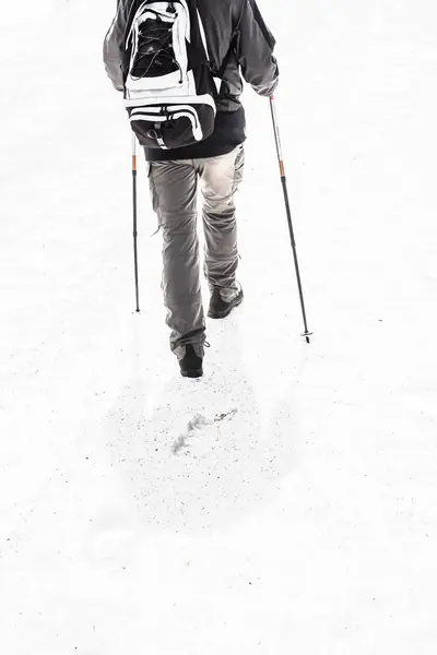 Mann unterwegs in schneebedeckten Bergen mit Wanderausrüstung 2 — Stockfoto