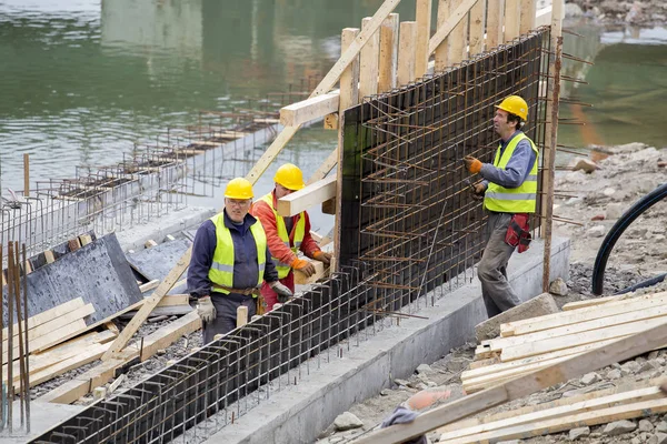 Arbetstagare som arbetar på stödmur, kopplingsförbehåll armeringsjärn — Stockfoto