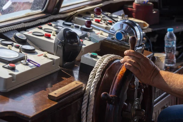 Panel sterowania w łodzi turystycznej z ręką na kierownicy — Zdjęcie stockowe