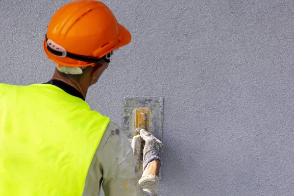 Lavoratore applicando intonaco decorativo sulla parete — Foto Stock