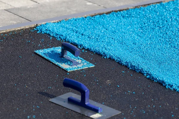 Rubber coating for playgrounds applied on the surface by a steel — Stock Photo, Image