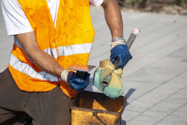 Werknemer schoonmaken van een vuile troffel met spons — Stockfoto