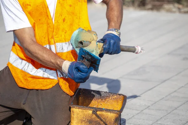 Worker cleaning a dirty trowel — Stock Photo, Image