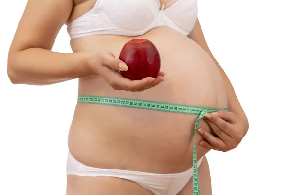 Donna incinta in biancheria intima con in mano mela rossa — Foto Stock