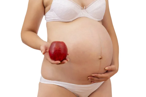 Pregnant woman in underwear holding red apple on white — Stock Photo, Image