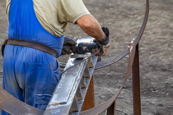 Arbeiter schleift Stück Metall — Stockfoto