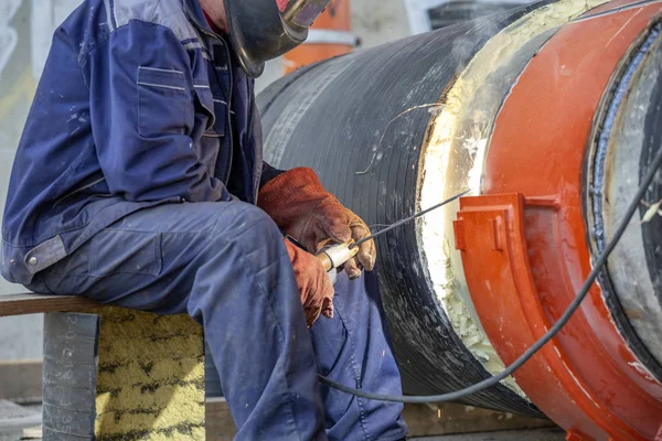 Worker welding pipeline outdoors using arc welding — Stock Photo, Image