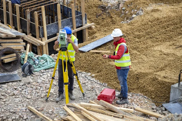 Unga lantmätare med teodolit och totalstation — Stockfoto