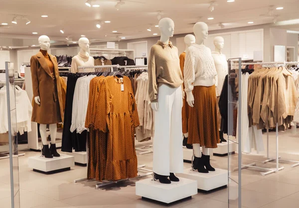 Güz mevsiminde beyaz mankenler alışveriş merkezindeki bir mağazada sıcak ve rahat giysiler.