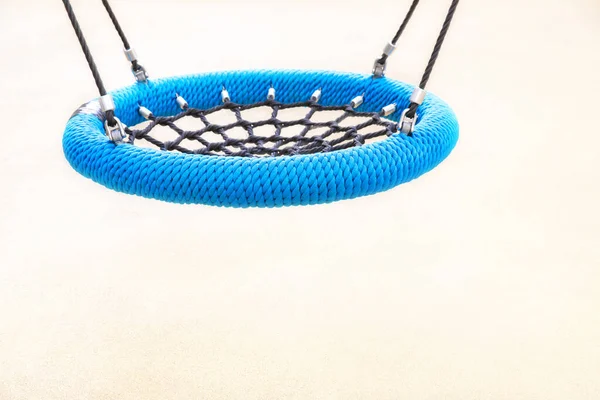 Oyun Alanı'nda mavi yuvarlak salıncak tipi yuva. Çocuklar ve ergenler için spor rekreasyon kavramı, mutlu bir çocukluk.