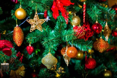 Zarif Noel arkaplanı, plastikten yeşil eko ağacı bir sürü renkli altın ve kırmızı oyuncakla süslenmiş..