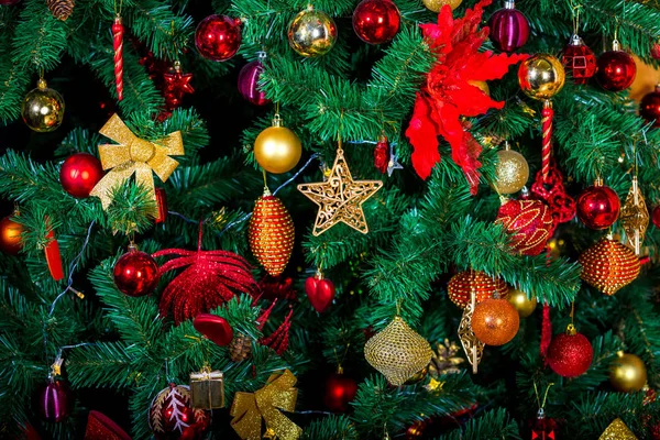 Zarif Noel arkaplanı, plastikten yeşil eko ağacı bir sürü renkli altın ve kırmızı oyuncakla süslenmiş.. - Stok İmaj