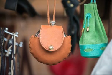 Kahverengi deri çantalı, el yapımı metal bir şişe..