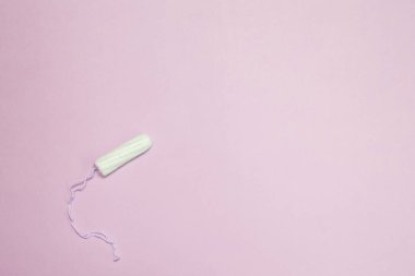 Pembe arka planda sıkıştırılmamış tamponlar, kadınların özel hijyen ve sağlık konsepti..