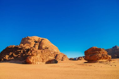 Mavi gökyüzüne karşı kırmızı ve turuncu kum dağları, Ürdün, Wadi Rum Çölü.