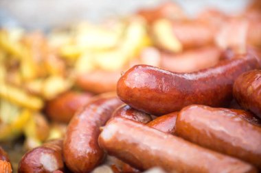 Sosisler yakın plan ızgara, patatesler kırsal tarzda. Fast-food restoranları ve sokak fuarları kavramı.