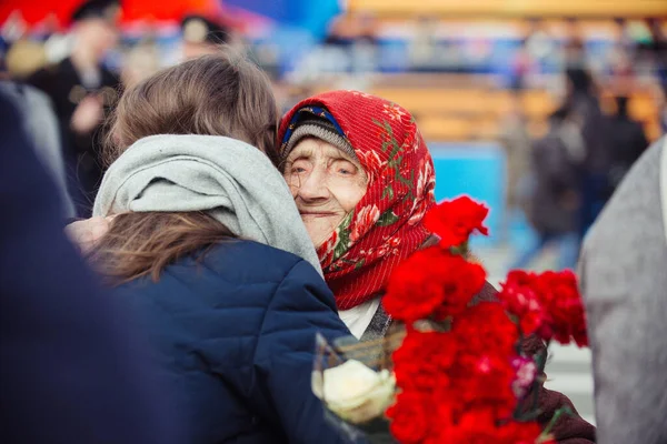 9 Mayıs 2017, Saray Meydanı, St. Petersburg, Rusya. 9 Mayıs bayramında, Yaşlı büyükannem, savaşın bitimi ve zafer günü onuruna karanfil çiçekleri ve selamlar alır..