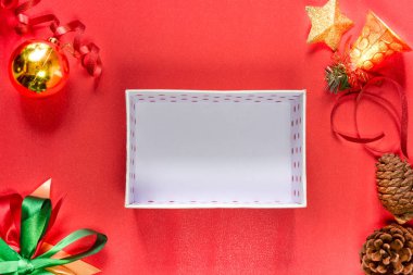 Noel kompozisyonu şenliği. Süslemeler, kırmızı ve altın süsler, kırmızı arka planda Xmas hediye kutuları. Noel için kutlama, yeni yıl, kış tatili konsepti. Düz yat, boşluğu kopyala.