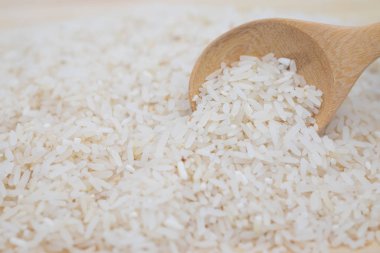 Pirinç ağacının arka planında tahta bir kaşıkta yakın plan çekimi. kopyalama alanı ile