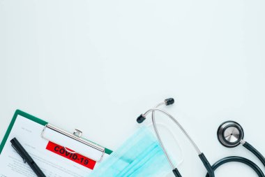 Hastanedeki en iyi doktor masası görüntüsü. Üzerinde steteskop, kağıt rapor ve maske olan bir pano. Coronavirus (COVID-19) ya da 2019-nCoV için doktor raporu verin. Coronavirus konseptini kontrol et.