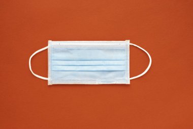 Kırmızı arka planda tıbbi maske var. Kirlilik ve gribe karşı korunma yüzü. Koronavirüsten (COVID-19) ya da 2019-nCoV 'dan yayılmaması için önleme hijyeni. Sağlık ve Tıp Konsepti.