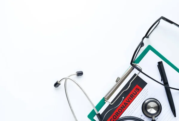 Top view of doctor office desk in the hospital. Which have stethoscope and clipboard with paper report. Report physician for check novel coronavirus(COVID-19)or 2019-nCoV. Coronavirus check concept.