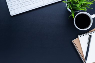 Ofiste, çalışma masası siyah. Not defteri ve kahveyle klavyenin üst görüntüsü. Modern yaratıcı tasarımcılar için yer var. Boş fotokopi alanı olan düz bir yer. İş ve finans kavramı.