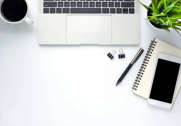 Workplace in office with white desk. Top view from above of laptop with notebook and coffee. Space for modern creative work of designer. Flat lay with blank copy space. Business and finance concept.